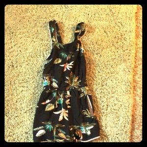 A black romper with Palm trees on it